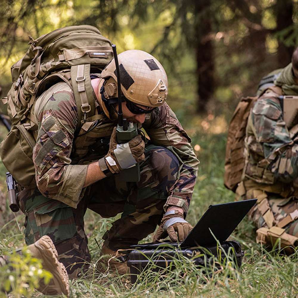 Soldiers operating rugged field electronics powered by lightweight military power systems